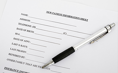 An image of a new patient information form with a pen